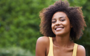 Black woman in tank top outdoors on a summer day