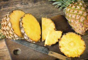 slice pineapple on a wood cutting board - mucus-fighting foods