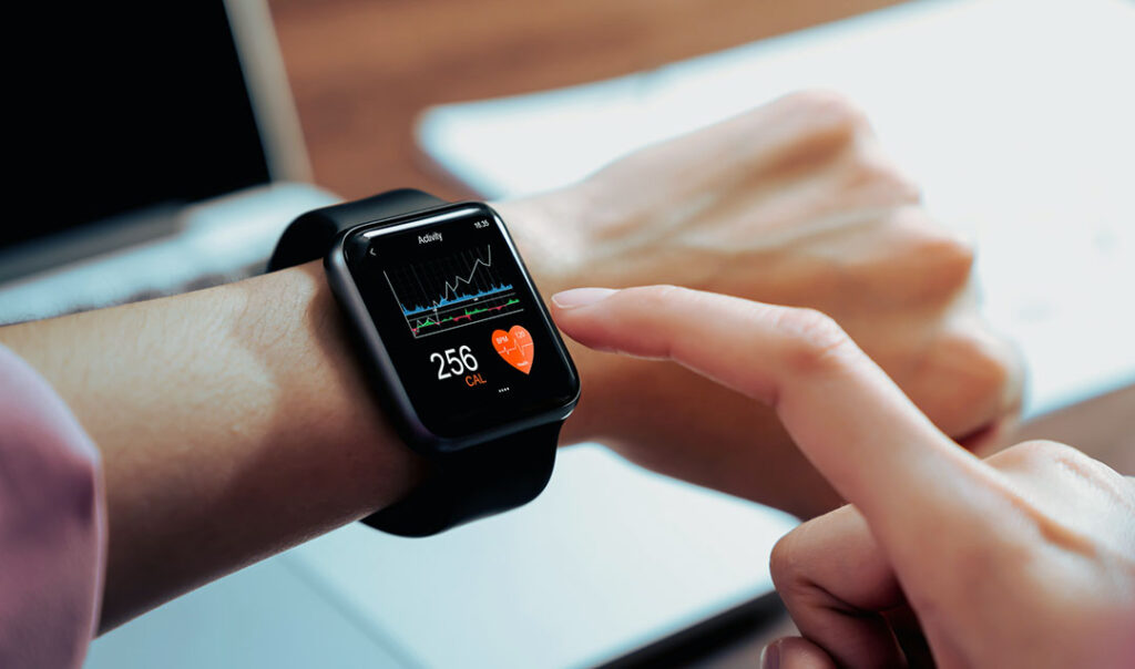 Close up of hand touching smartwatch with health app on the screen - walking and fitness app