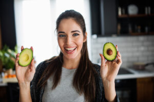 woman holding an avocado - avocado health benefits