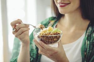 woman eating a heart healthy breakfast - foods to help with high blood pressure