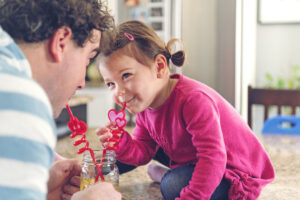 daughter and dad sharing a healthy drink at home - immune system function - cold and flu season