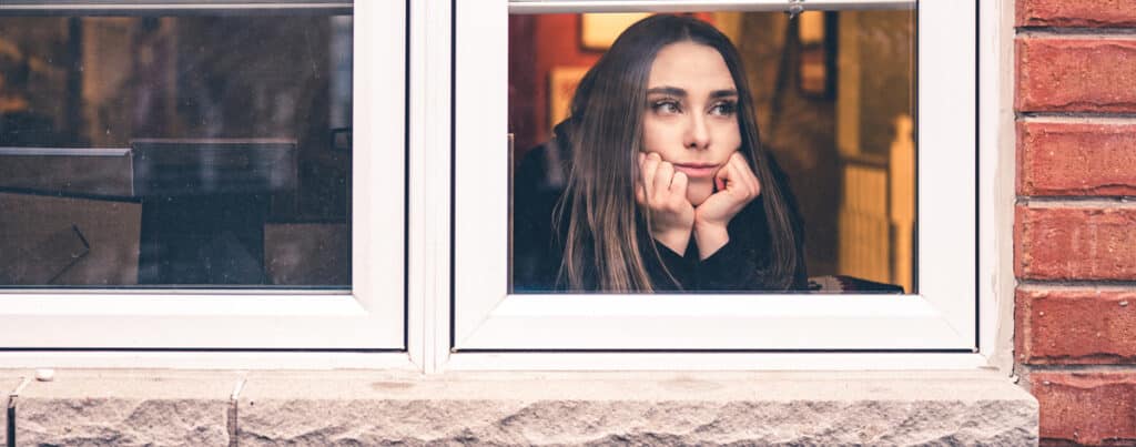 woman stay at home looking out window