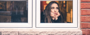 woman stay at home looking out window