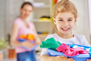 young girl helping mom with laundry chores