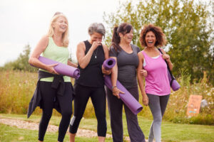 group of four women going to outdoor yoga class