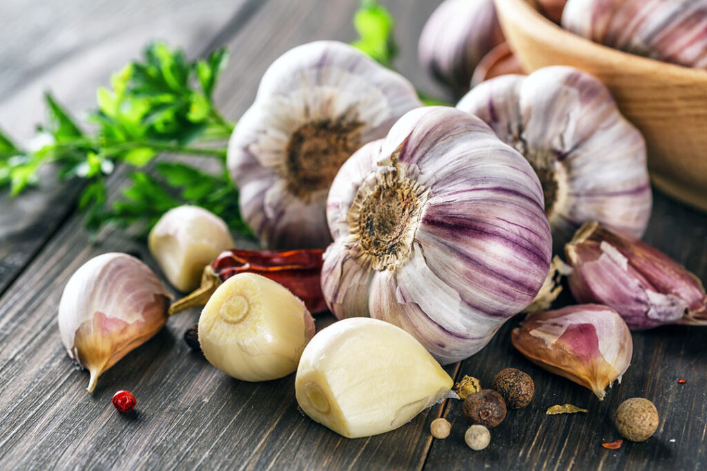 Closeup of Garlic bulbs on wooden table - mucus fighting food