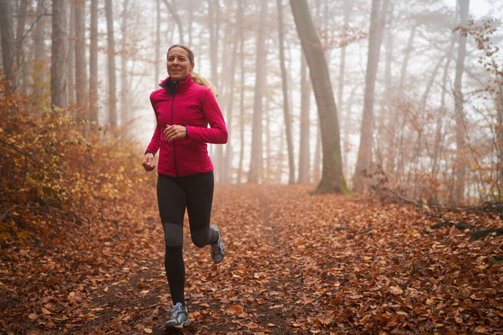 woman trail running in the fall