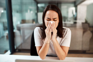 Dealing with a stuffy nose - woman blowing her nose