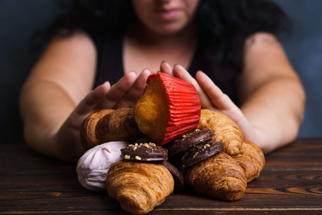 Sugar addiction, nutrition choices, motivation and healthy lifestyle. Cropped portrait of overweight woman refusing sweet food - reasons behind an afternoon slump