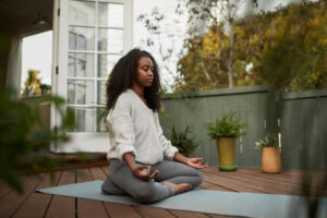 woman doing lotus pose on patio - morning yoga session - meditation