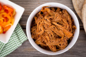 ulled pork bowl over a wooden plank table