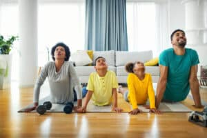 Family exercising yoga at home - health goals