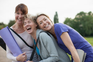 Smiling women holding yoga mats