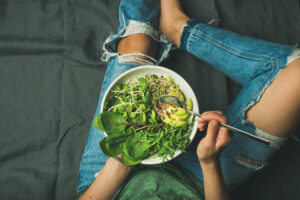 Vegetarian breakfast bowl with greens: spinach, arugula, avocado, seeds and sprouts