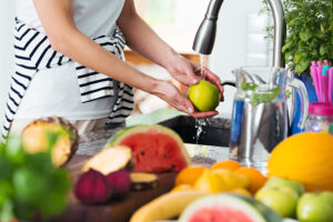 woman washing an apple - dirty dozen - clean fifteen - alignlife