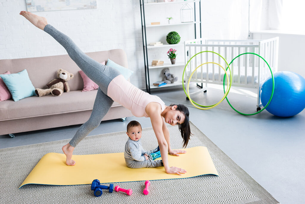 young mother practicing yoga in One Legged Downward-Facing Dog pose morning yoga