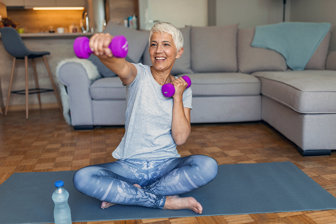 Senior Woman Exercising With Dumbbell At Home