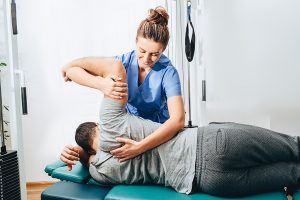 chiropractor adjusting woman - chiropractic care myths and facts