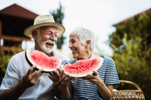 senior couple eating watermelon in summer