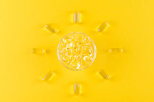 vitamin D supplements shaped into a sun on yellow background