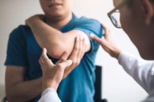 chiropractor checking man's shoulder