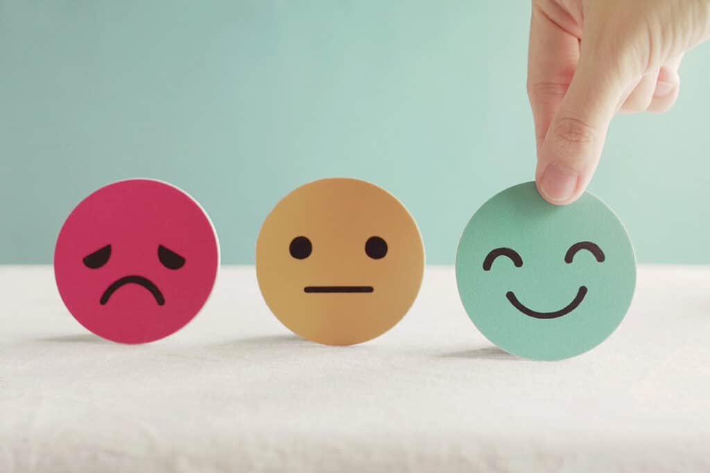 Hand choosing green happy face - magnesium for better moods
