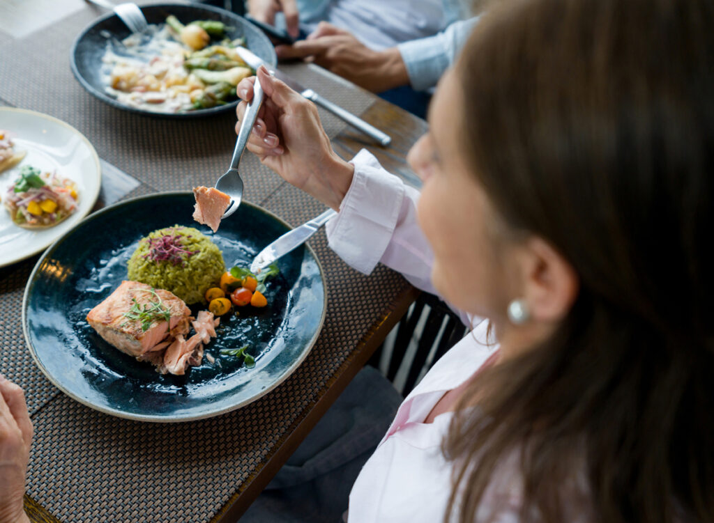 woman eating salmon - heart healthy omega 3 - foods that fight inflammation