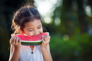 girl eating healthy watermelon slice - summer snacks