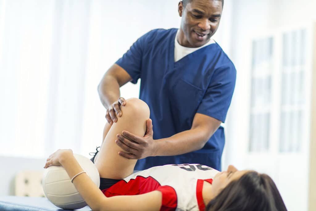 student athlete getting care for sports injury - sports physical