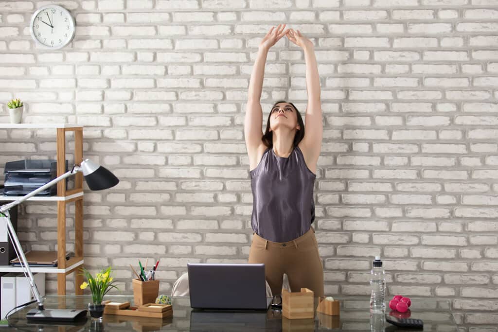 woman stretching at office - energy exercise