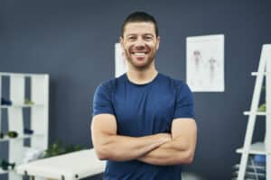 Male chiropractor smiling in office - AlignLife