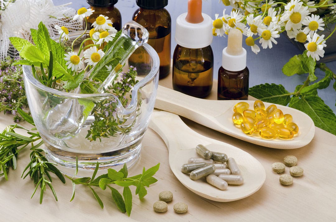 natural remedies for cold - Rosemary, mint, chamomile, thyme in a glass mortar. Essential oils and herbal supplements.