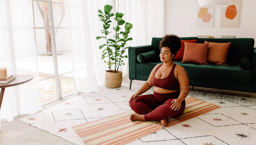 Healthy woman practicing yoga meditation at home - how to lose weight