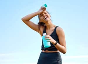 Sporty young woman sweating after using exercise to help sweat out body toxins