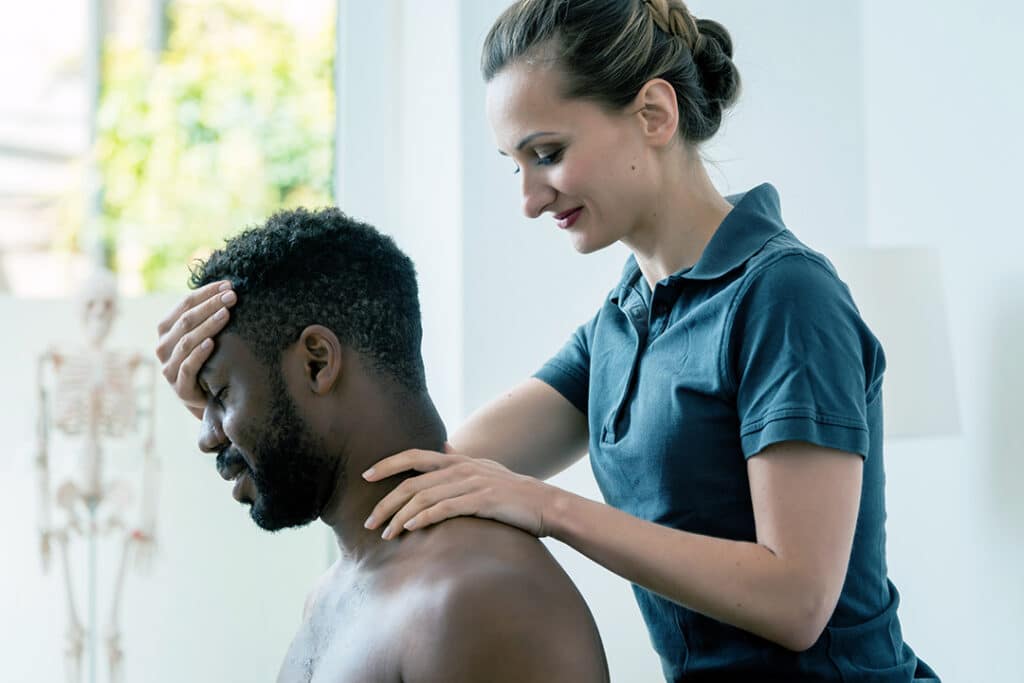 Woman chiropractor adjusting man's neck for headache relief