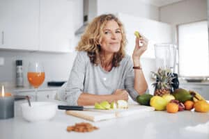 Woman eating healthy snack in kitchen - how functional nutrition works