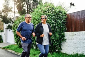 senior couple keeping fit - exercising outdoors to help with knee pain