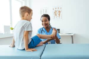 pediatric chiropractor is checking boys muscles and bones