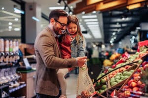 dad and daughter choosing healthy foods at grocery store- trying new foods