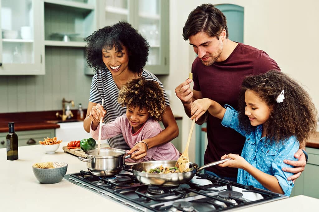 family cooking a meal together in their kitchen - picky eaters - trying new foods