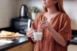 young woman drinking a cup of milk