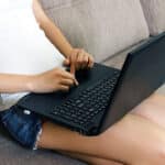 woman sitting on couch with laptop