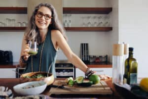 Healthy senior woman smiling while holding some green juice - foods with magnesium