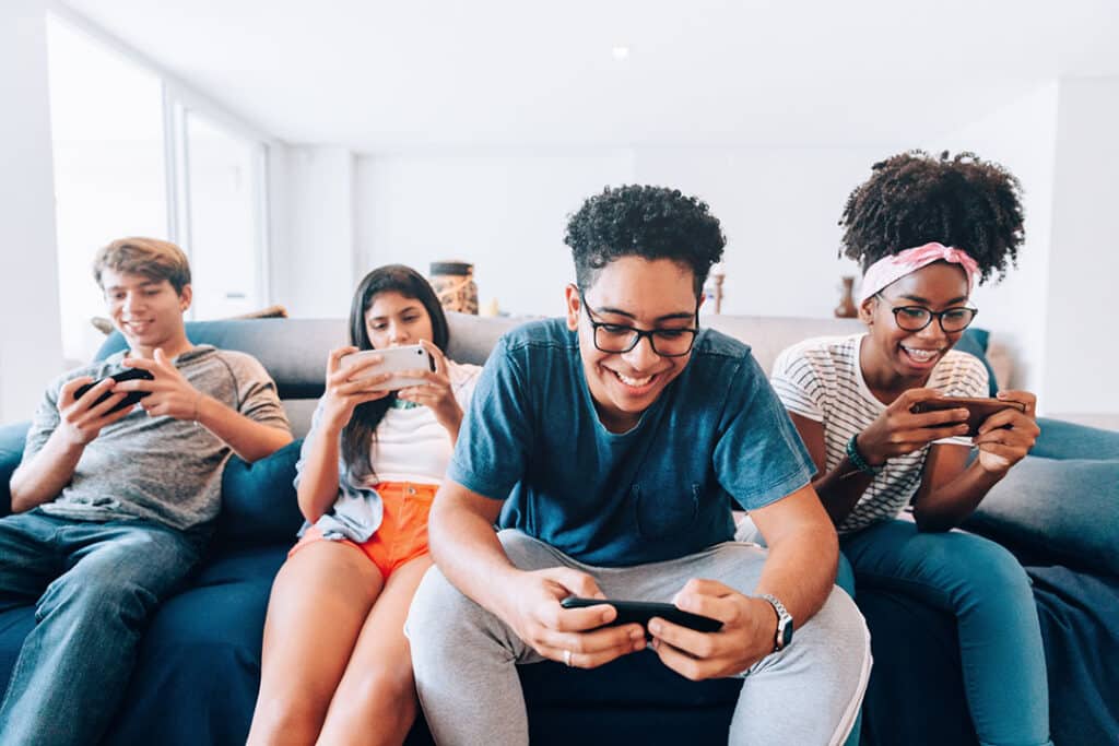 teens on tech sitting on a couch with poor posture