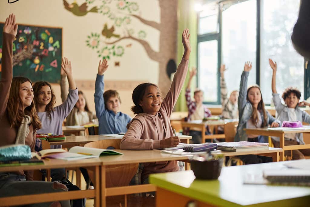 large group of students sitting at desks in a classroom - desk ergonomics