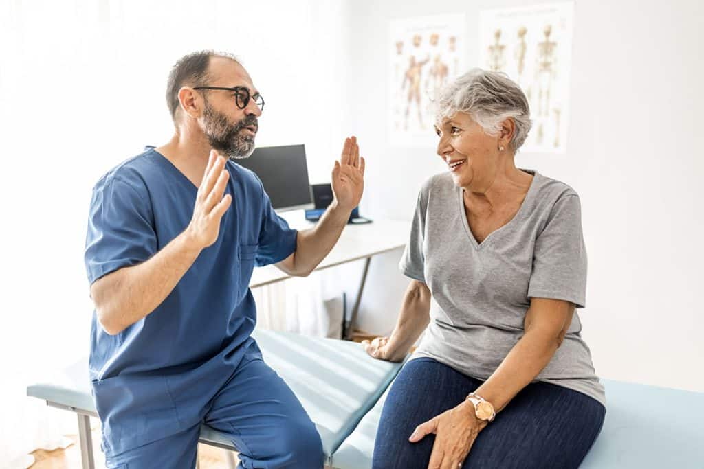 Senior woman talking to chiropractor about gut health