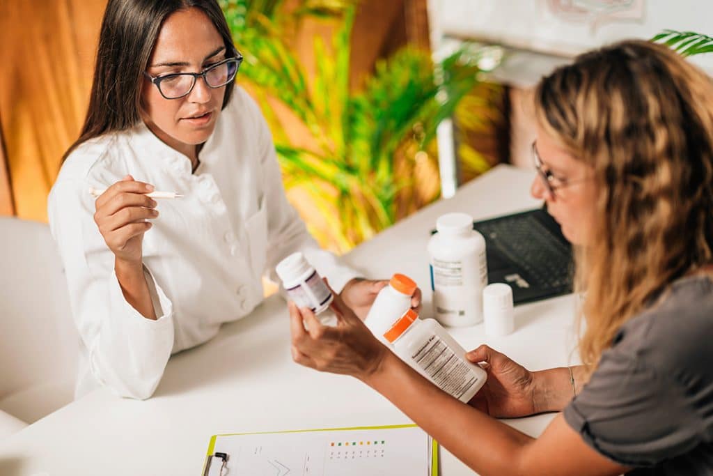 Woman looking at supplements with functional nutritionist