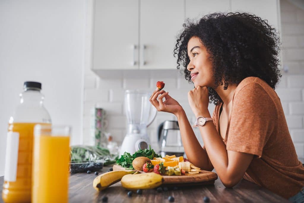 woman eating a healthy snack of fruit