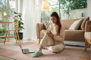 Woman sitting on floor practicing gratitude by journaling